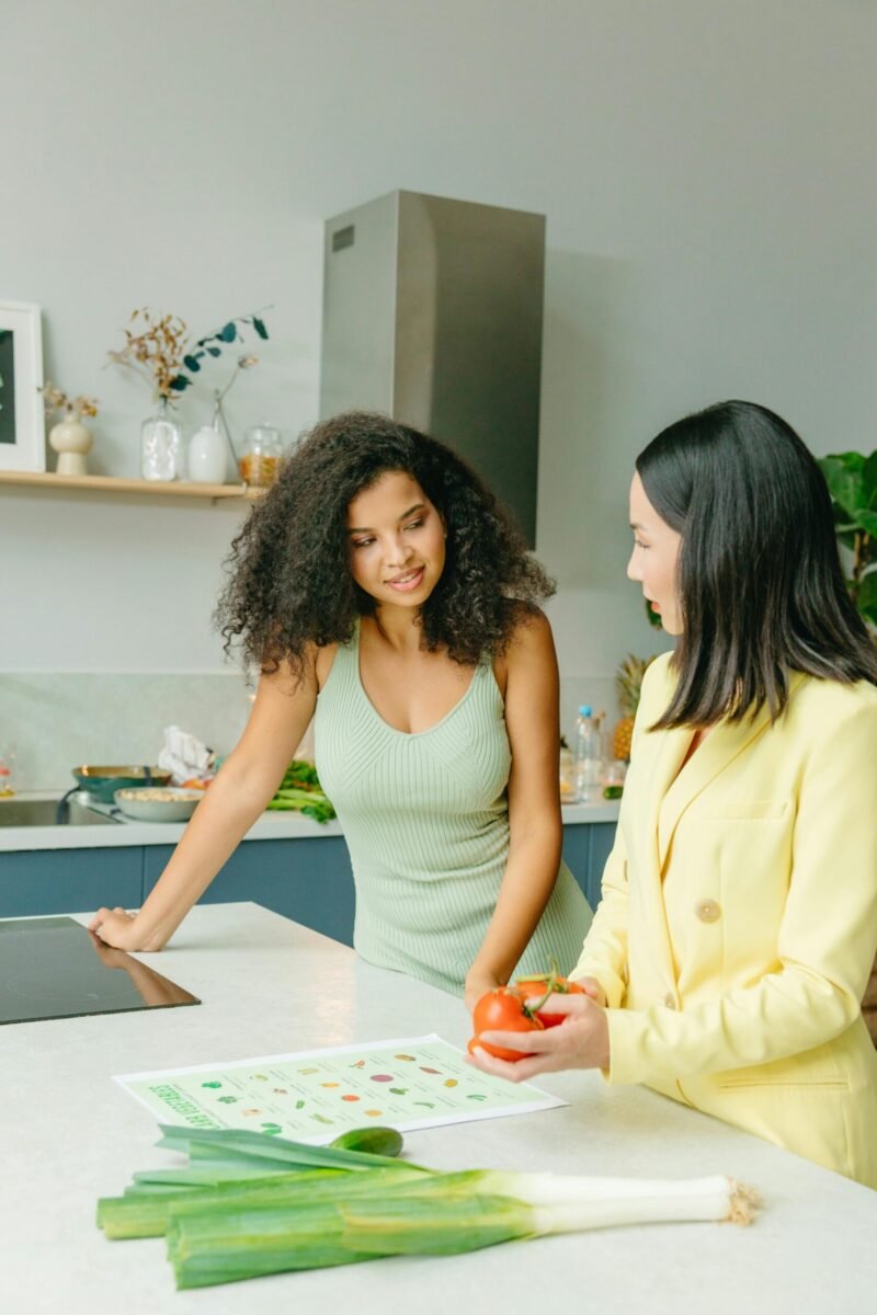 Dietary consultation in a home kitchen with nutritionist and client discussing healthy eating.